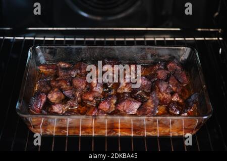 Roasted pieces of pork in a glass container. Close up. Stock Photo