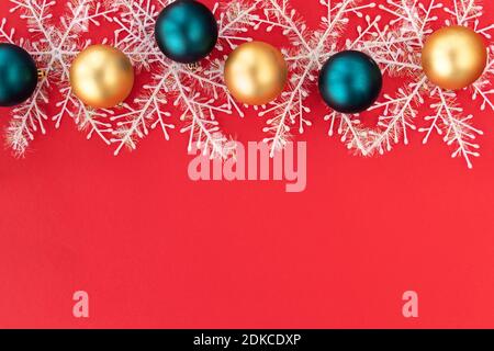 Colorful Christmas balls and snowflakes. Golden and blue Christmas balls on a red background with space for text. Christmas and Xmas concept.Copy space. Top view. Flat lay Stock Photo