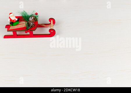 santa claus on a sleigh carries gifts on a white wood background with gold veins Stock Photo