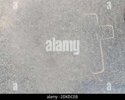 A closeup shot of a cross painted on a stone wall Stock Photo
