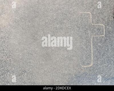 A closeup shot of a cross painted on a stone wall Stock Photo