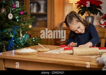 cute girl makes and decorates christmas gingerbreads Stock Photo