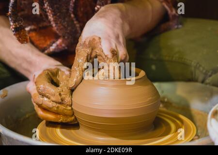 Close up view - professional male potter making pot in pottery workshop Stock Photo