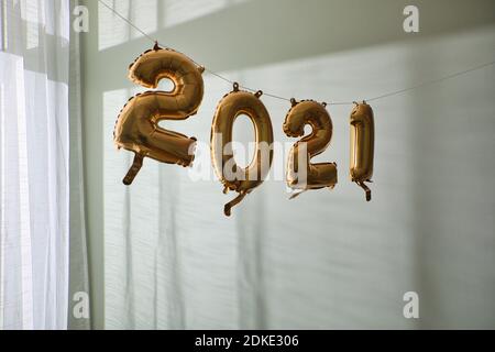 2021 balloons hanging on string indoors. Stock Photo