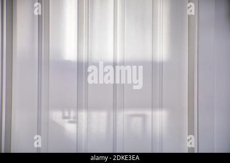White wooden door pattern abstract with vertical lines and day shadows. Stock Photo