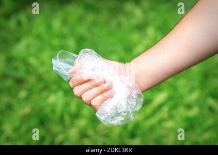 The person holds used crumpled plastic debris in his hand. Environmental problem concept. Stock Photo