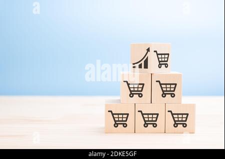 pyramid of wooden cubes with sales icons. Sale volume increase make business grow concept. top cube of the sales pyramid with icon graph and shopping Stock Photo