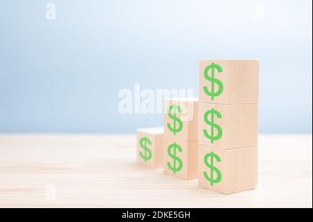 Ladder made of wooden blocks with dollars. Increase, rise, grow, up. Financial or business growth concept. dollar icons on wooden cubes. copyspace. mo Stock Photo