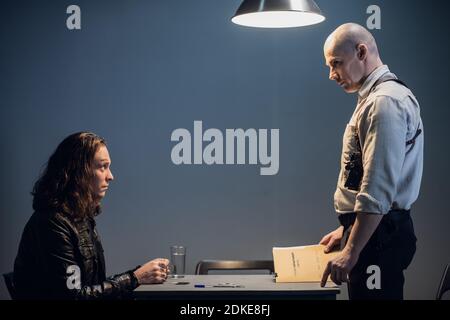 A young detective interviews a suspect in a crime. Stock Photo