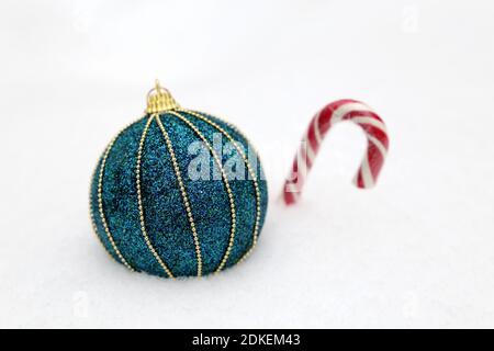 Christmas toy ball with candy cane on the snow. Winter background for New Year celebration, greeting card Stock Photo