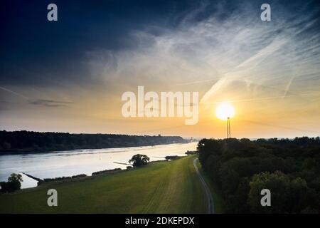 Riverside landscape, Elbtalaue, Germany, Northern Germany, Lower Saxony, Elbe, banks near Hohnstorf, aerial view, looking upstream, golden hour, the sun is behind the mast of a high-voltage line Stock Photo