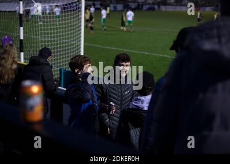 Young home supporters on the terracing during the second-half as Marine play Hyde United (in white) in an FA Trophy first round tie at the Marine Travel Arena, formerly known as Rossett Park, in Crosby. Due to coronavirus regulations which had suspended league games, the Merseysiders’ only fixtures were in cup competitions, including their forthcoming tie against Tottenham Hotspur in the FA Cup third round. Marine won the game by 1-0, watched by a permitted capacity of 400, with the visitors having two men sent off in the second half. Stock Photo