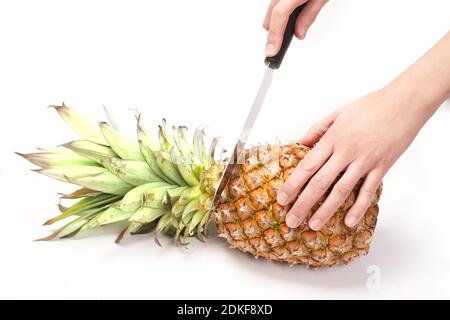 Cutting pineapple with knife on white background Stock Photo