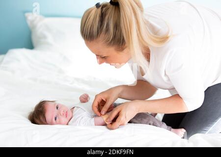 mother or doctor or nurse is putting a plaster on the baby hand