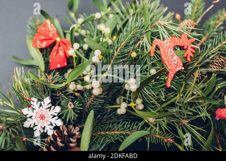 Christmas and New Year fresh fir, pine, mistletoe branches, cones decorated with red ornaments, bows, toys, deer. Holiday art Stock Photo
