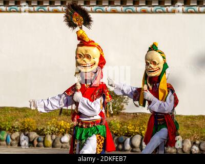 Unidentified monks in Citipati (protector deity) masks perform a religious masked and costumed mystery dance of Tantric Tibetan Buddhism on Cham Dance Stock Photo