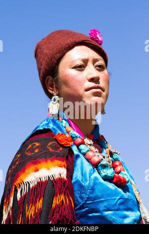 Leh, Jammu and Kashmir, India - Sep 01, 2012: the Ladakhi tribal woman with intense look in traditional clothing in the processing on the traditional Stock Photo