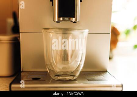 Brewing fresh coffee from the espresso machine. Preparing cappuccino in a glass transparent coffee cup. Stock Photo
