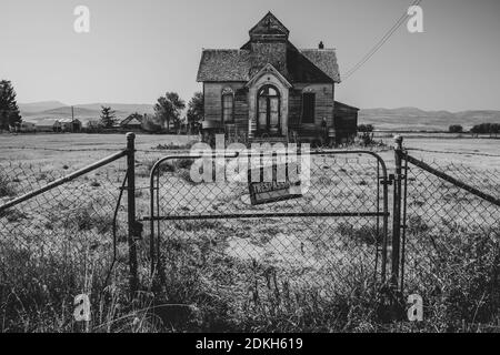Old, abandoned LDS mormon church in Ovid, Idaho. No trespassing sign and fence Stock Photo