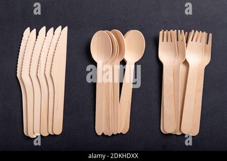 Wooden cutlery on the table. Utensils used in the fast food bar. Dark background. Stock Photo
