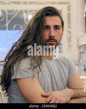 Attractive, young bearded male model with long hair posing indoors. Style, trends, fashion concept. Stock Photo