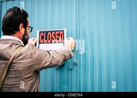 Failed business man store owner with closed signs on the door of his shop - coronavirus lockdown economy emergency crisis concept with close activity Stock Photo