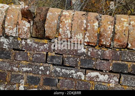 Closeup of huge cracks and missing bricks on an old brick wall Stock Photo