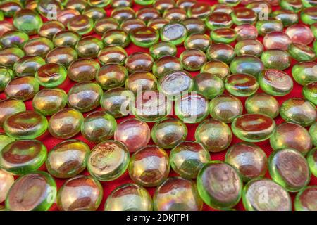 Green glass beads on bright red background Stock Photo