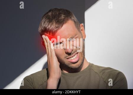 Man touching his temple and having strong tension headache. Cluster headache Stock Photo