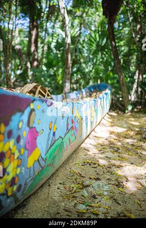 Colorfully painted planter in the middle of a tropical forest Stock Photo