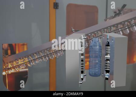 Mould of PET plastic bottles drinking water container on bottle blowing machine background Stock Photo