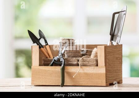 Box with set of gardening supplies on table Stock Photo