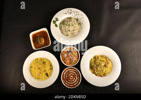 three rice dishes of different flavours served in one table with spicy dal fry,egg curry and paneer Stock Photo