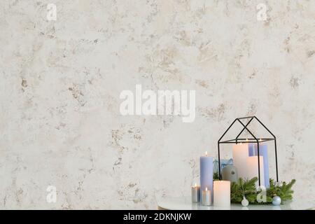 Christmas wreath with burning candles on table in room Stock Photo