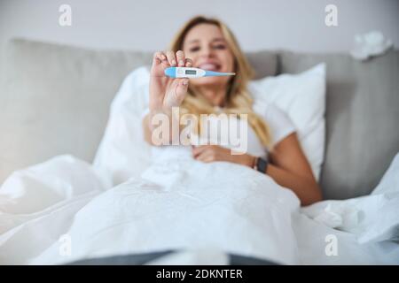 Focused photo on female hand that showing thermometer Stock Photo