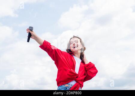 Music and life. teen girl singing song with microphone. having a party. Happy kid with microphone. Singing Songs in karaoke. Lifestyle and People Concept. make your voice louder. Stock Photo