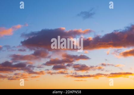 Cumulus sunset clouds with sun setting down bright gradient Stock Photo
