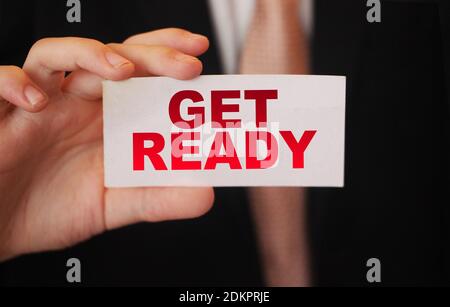 Get ready, message on business card shown by a businessman. Business risk management concept. Exams concept. Stock Photo