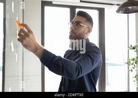 Pensive Arabic male employee do creative thinking in office Stock Photo
