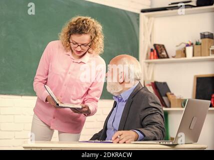 Maybe it was the wrong decision. senior teacher and woman at school lesson. student girl with tutor man at blackboard. studying through online e-learning system. pass exam. teachers room. Stock Photo