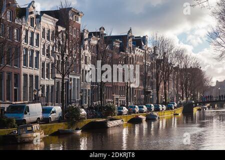 Amsterdam, Netherlands - February 24, 2017: Amsterdam canal view, cars are parked on a coast near old living houses Stock Photo