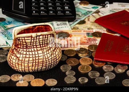 coins and paper money and two international passports lie on a black wooden table inscription russian federation Stock Photo