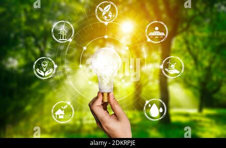 Green energy innovation light bulb with future industry of power generation icon graphic interface. Concept of sustainability development by Stock Photo