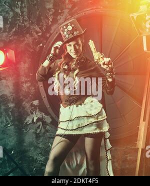 Steampunk woman with mechanical gun. Beautiful girl, model in the style of a steampunk in a beautiful creative studio. Fashion, style Stock Photo