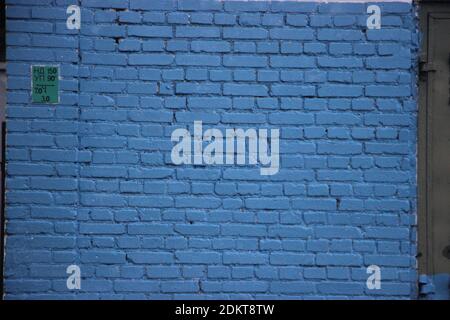 Old brick wall painted into solid blue. Stock Photo