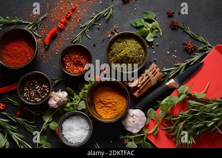 Variety of spices and herbs on kitchen table. Colorful various herbs and spices for cooking on dark background Stock Photo