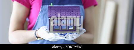 Builder holds the house in his hands. Stock Photo