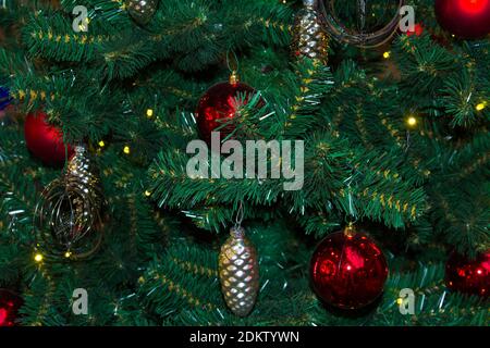 Artificial fir tree with Christmas decorations in the form of stars, cones and balls. Close up. Stock Photo