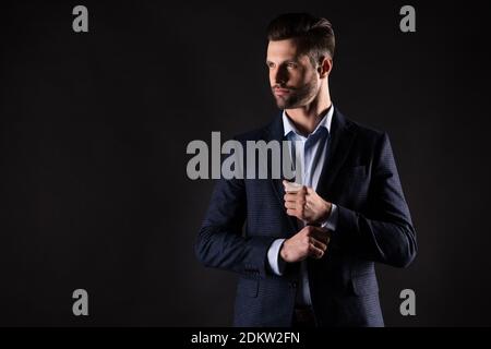 Portrait of his he nice attractive perfect rich wealthy trendy guy corporate partner mr mister fastening button preparing dressing isolated on dark Stock Photo