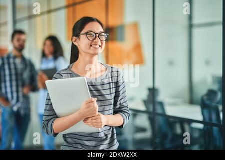Cheerful young woman feeling happy while going to work Stock Photo